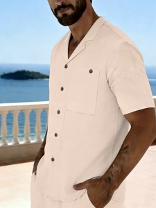 Detail of men's beige linen beach shirt featuring campfire collar and wooden buttons