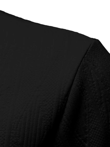 Close-up of black polo shirt shoulder seam showing fine knit texture and stitching details