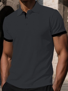 Detail of dark charcoal polo shirt featuring waffle knit texture and black ribbed cuffs