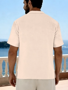 Back view of men's loose linen short sleeve beach shirt in beige with side slit detail