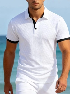 Détail du polo blanc en tricot avec texture jacquard à losanges et bords contrastés noirs