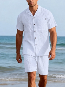 Men's white linen resort set with Cuban collar shirt and shorts on a sunny beach
