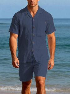 Detailed texture of navy linen short-sleeve shirt and drawstring shorts on beach