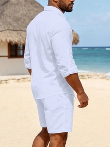 Men's white linen long sleeve shirt and shorts set styled in a beach resort setting