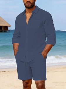 Detail of men's linen suit showing breathable dark blue shirt and drawstring shorts on beach