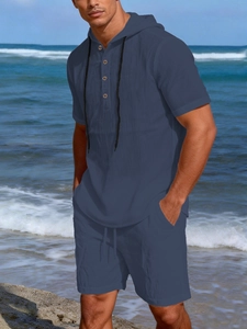 Detail of navy blue linen texture on men's hooded shirt and shorts set by the beach