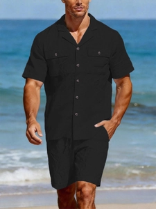 Detail of men's black linen shirt and shorts set showing chest pockets and light fabric