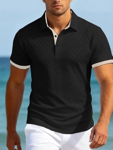 Gros plan du polo noir en maille avec col contrasté beige et texture à losanges