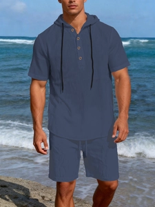 Detail of grey blue linen men's leisure set showing wooden buttons and drawstring hood