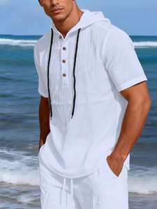 Detail of white linen hooded Henley shirt with wood buttons and drawstring at beach