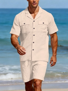 Men's linen set detail showing short sleeve button-up shirt and drawstring shorts on beach