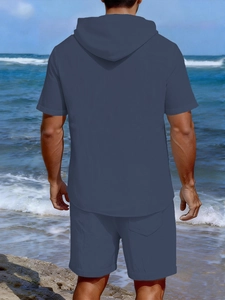 Rear view of men's navy blue hooded linen leisure set on a sunny beach landscape