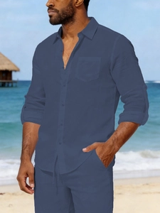 Men's navy linen long sleeve shirt and shorts set shown in a sunny beach setting