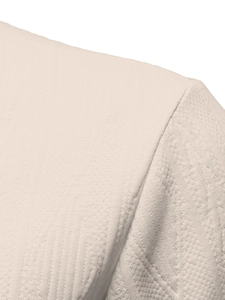 Macro detail of high-quality knitted fabric and shoulder stitching on a beige polo shirt