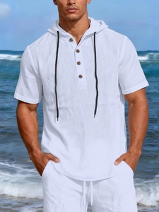 Detail of white linen hooded shirt for men with wooden buttons on a sunny beach background