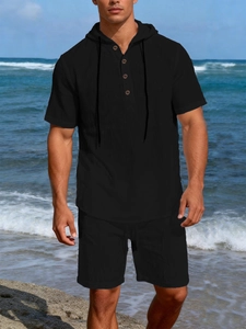 Close-up of men's black linen beach set featuring a hooded Henley shirt and casual shorts