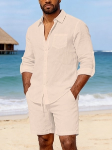 Close-up of linen shirt with chest pocket and drawstring shorts set on beach background