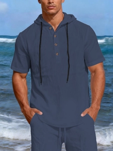 Detail view of navy linen hoody shirt showing buttons, drawstrings and natural texture