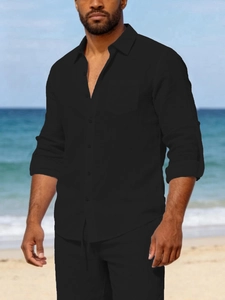 Detailed close-up of a men's black linen shirt with adjustable sleeves and chest pocket