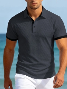 Détail d'un polo homme gris anthracite avec motif géométrique en tricot jacquard