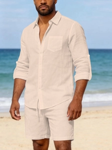 Detail of beige linen set with chest pocket and drawstring shorts on a sunny beach