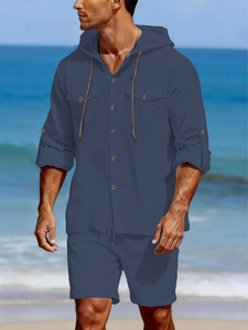 Détail de chemise en lin bleu foncé avec capuche, poches poitrine et manches retroussables