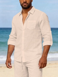Detail of men's beige linen set featuring button-up shirt and shorts on beach
