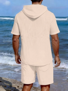 Rear view of men's beige linen short-sleeve hoodie and matching shorts set on beach