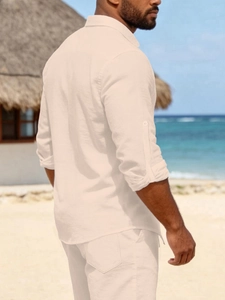 Detail of men's linen beach shirt with adjustable roll-up sleeves in light beige