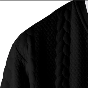 Close-up of black knitted cardigan featuring 3D cable knit and diamond jacquard texture
