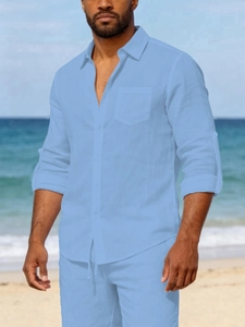 Close-up of light blue linen shirt with chest pocket and roll-up sleeves for men