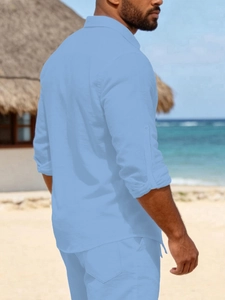Detail of light blue linen shirt featuring adjustable sleeve straps and classic collar