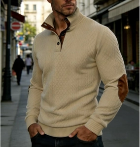 Close-up of beige knitted sweater featuring brown elbow patches and a buttoned high collar