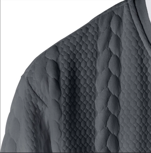 Macro shot of dark grey sweatshirt featuring 3D embossed quilted honeycomb and cable textures