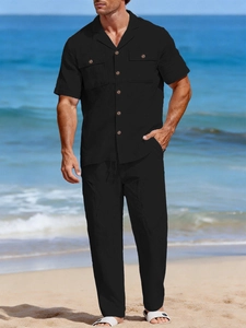 Close-up of black linen short-sleeve shirt with wood buttons and matching trousers