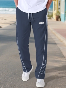 Dettaglio dei joggers blu navy con stampe di stelle bianche sull'orlo e strisce laterali