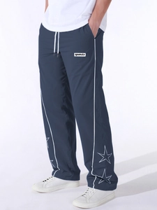 Dettaglio della stampa a stelle e strisce laterali sui pantaloni sportivi blu
