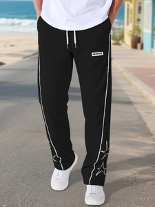 Dettaglio dei pantaloni sportivi neri con ricamo di stelle e strisce laterali