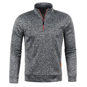 Detail of grey quarter-zip knit sweater featuring a red contrast zipper and leather hem tag