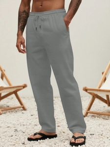 Close-up of men's gray casual linen pants with elastic waist and black drawstring detail