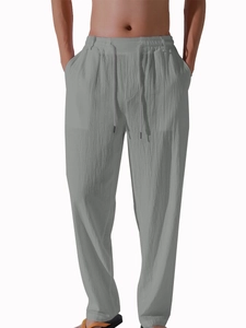 Detailed view of grey linen cotton pants featuring drawstring waist and fabric texture