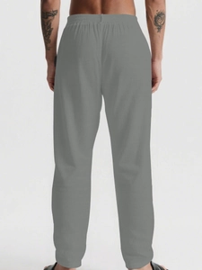 Detail view of men's casual mid-gray trousers featuring an elastic waistband and relaxed fit