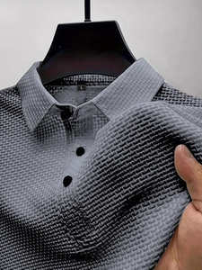 Detail of grey gradient mesh polo shirt showing three-button placket and knit texture