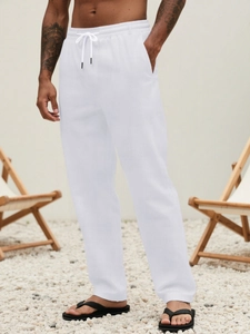 Close-up of white breathable cotton linen pants with drawstring waist and side pockets