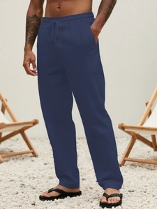 Detail view of navy blue cotton linen trousers with elastic drawstring waist and side pockets