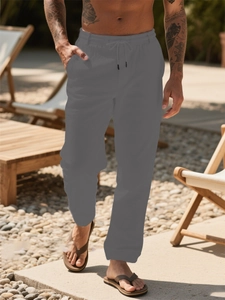 Detail of dark grey linen trousers showing elastic drawstring waist and textured fabric