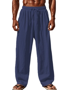 Detail of navy cotton linen trousers featuring elastic waistband and drawstring cords