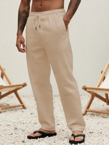 Detailed close-up of men's breathable cotton linen trousers with drawstring waist and pockets