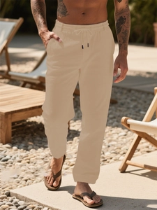 Detail of light beige men's linen trousers with elastic waist and drawstring cords