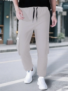 Detail of grey cargo pants featuring adjustable drawstring waist and functional side pockets